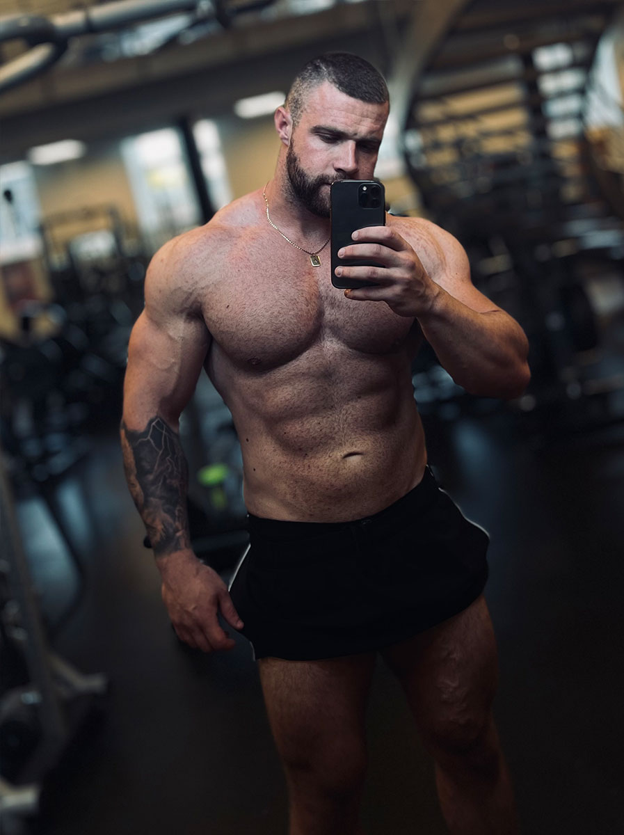 Coach posing at gym topless