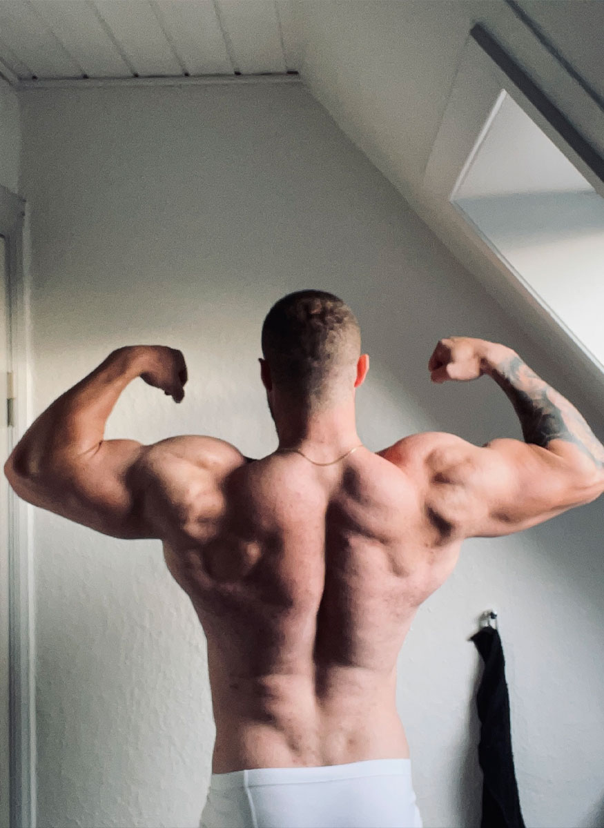 Coach from behind flexing his biceps